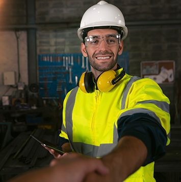 Portrait of a man giving an handshake in an industrial facility